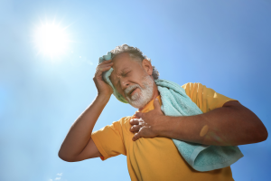man is in the sun covering his head with a towel to help with heat exhaustion